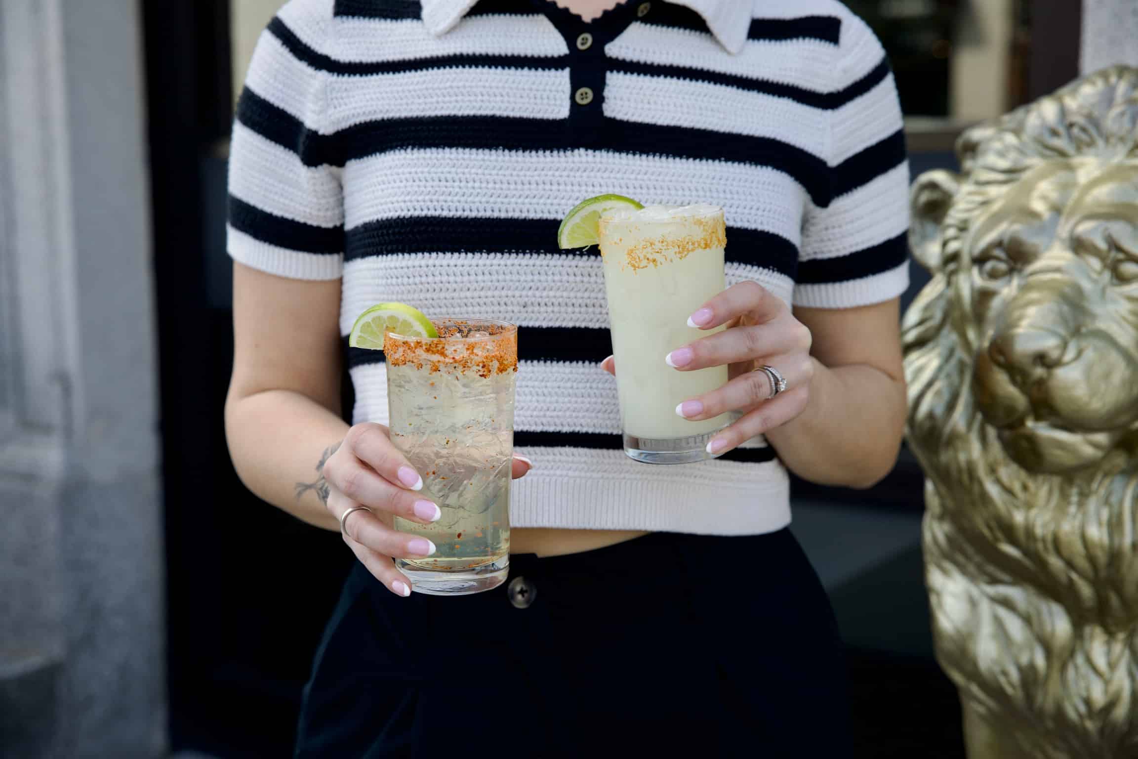 holding 2 margaritas